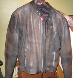 Derek holds up the well-worn and obviously man-sized leather jacket