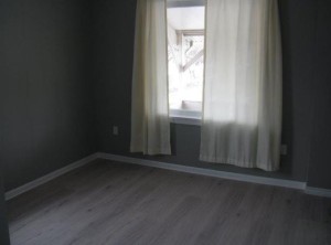 room redone with soft grey, white curtains and a wood floor