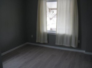 room redone with soft grey, white curtains and a wood floor
