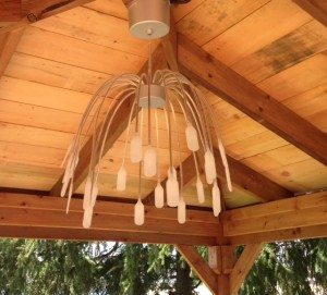 chandelier with hanging white wires with flat, white bulbs on the end