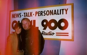 Michael Burgess and I, arm in arm, in front of the News-Talk-Personality-CHML-900 banner in that radio station's control room
