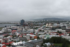 View of the coastal city of Reykjavik with colourful rooftops and a curved coastline along the ocean