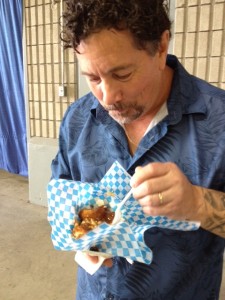 Derek has a grin as he's about to spear a poutine ball in a paper bowl and try it for the first time 