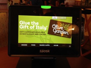 small computer monitor displays an Olive Garden gift card ad and the options to choose meals, drinks, pay, games and apps and ecard.