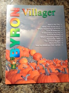 Magazine with grey background and a pile of pumpkins pictured, along with a table of contents and the title, Byron Villager, in various colours