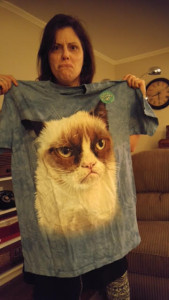 Me, making a grumpy face while holding my new Grumpy Cat t-shirt. The cat face is the size of an ottoman!