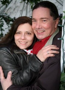 A closeup of us in a hug. I'm wearing a leather jacket and Derek has riding gear on including a red bandana around his neck.