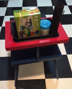 Table from behind shows red top with cutout where basket full of toys fits snugly
