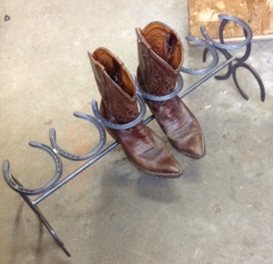 Boot rack with horsehoes holding the boots in place, and three horseshoes on each end to form the stand.