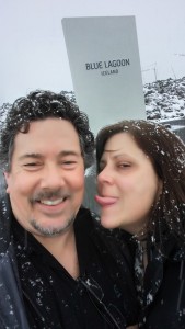 Derek laughs as I stick out my tongue to catch fat snowflakes in front of a tall sign that reads Blue Lagoon