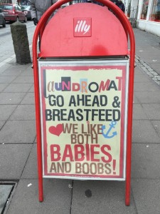 Sign reads: Go ahead and breastfeed. We like both babies and boobs!