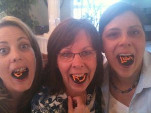 Barb, Kelly and I stick out our tongues that have cupcake toppers on them