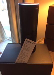 Amazon Echo - an eight-inch tall black cylinder, sitting on the box it came in. 