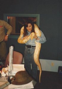 Me dressed in denim with a 10 foot long, fat snake around my neck. Im holding it just below its head, as I was told to do.