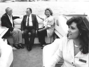 Riding on a boat in Lake Ontario. Doug at far left talking to some older, obviously wealthy couple, and me smiling in the foreground