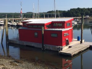 Red home/boat is built entirely from shipping containers