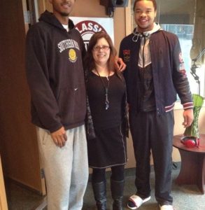 I'm dwarfed by two giant basketball players, one of whom's head was cut off by the photographer.