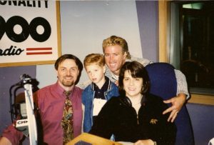 Photo of host Bill Kelly with me, football player Matt Dunigan and his young son in the CHML studio