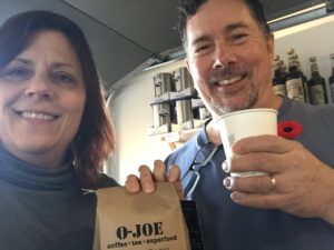 Derek and I hold up our coffee cups in salute, and a bag of O-Joe beans.