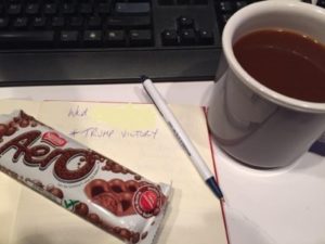 Aero bar and a full cup of coffee beside the words in my logbook TRUMP VICTORY