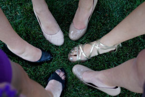 a circle of women's feet, each wearing a different type of show