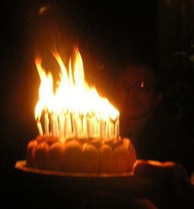 birthday cake with candles burning in a huge flame