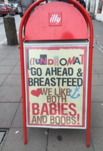 Sign reads: Go Ahead and Breastfeed, We Like both Babies and Boobs!