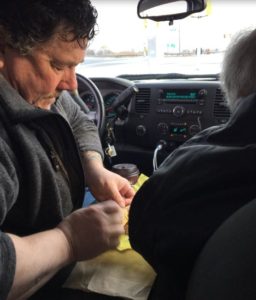 Taken from the back seat of the truck, Derek is separating the sections of Dad's egg McMuffin, while Dad waits