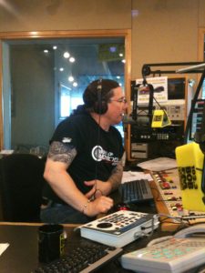 Derek talking into a microphone, on air at Bob FM in London