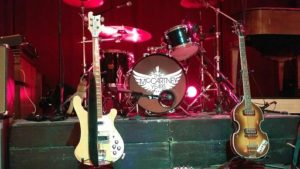 Stage shot of The McCartney Years logo on the bass drum and two guitars on their stands, taken before the show started