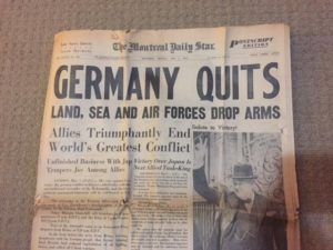 Headline reads Germany Quits. Land, sea and air forces drop arms, dated May 8, 1945