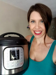 Woman holds her Instant Pot - a programmable, stainless-steel pot with a black lid