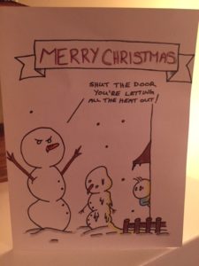 Drawing of a snowman and a melting snowman on a lawn. A man's head is peeking out of an open door and the big snowman says, Shut the door - you're letting all the heat out!