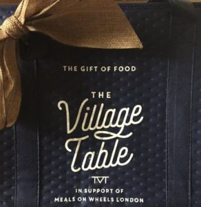 Navy blue thermal shopping bag with white lettering: The Gift of Food - The Village Table, a program supporting Meals on Wheels London