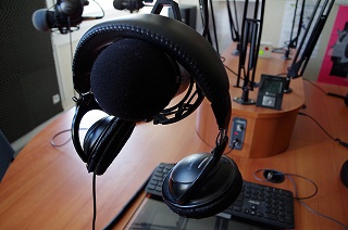 headphones resting on a microphone in a broadcast studio