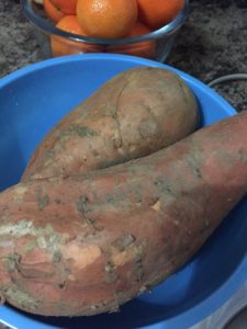 two one-pound yams in a blue bowl with a clementine in the background for perspective