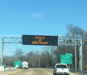 Overhead highway sign reads Buckle Up Sweetheart