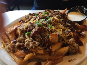 huge plate of fries smothered in BBQ rib meat with shredded cheese, chopped onions and lots of BBQ sauce