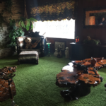 The infamous jungle room has turf-like green carpet, a huge chair and ottoman coverd in some kind of fur, as well as big, laquered wood tables
