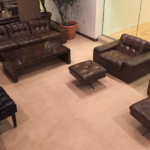 Shot from overhead, the lounge features manly, brown leather couches and chairs with a piano along one wall