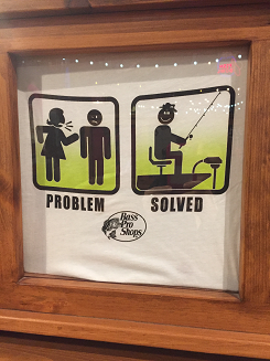 T shirt shows a stick figure woman yelling at a stick figure man. Underneath it says "problem". In the next box the stick figure man is fishing. Underneath it says "solution". 
