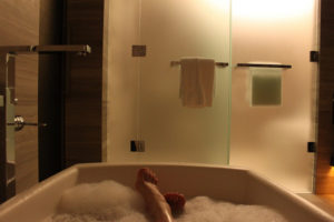 woman's feet at the end of a tub, in a bubble bath