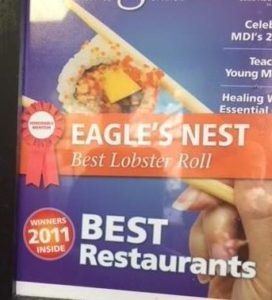 Framed magazine covers proclaiming Eagle's Nest restaurant one of the best in Maine and as having the best lobster roll in the state