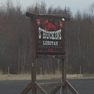 Tall wooden sign reads Shuckins Lobstah