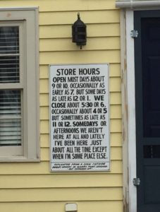 Sign reads: Store hours. Open most days at 9 or 10, occasionally as early as 7 but sometimes as late as 12 or 1. We close most days at 5:30 or 6 but occasionally as early as 4 and sometimes as late as 11 or 12. Somedays or afternoons we're not here at all but lately we've been here just about all the time except when we're somewhere else.