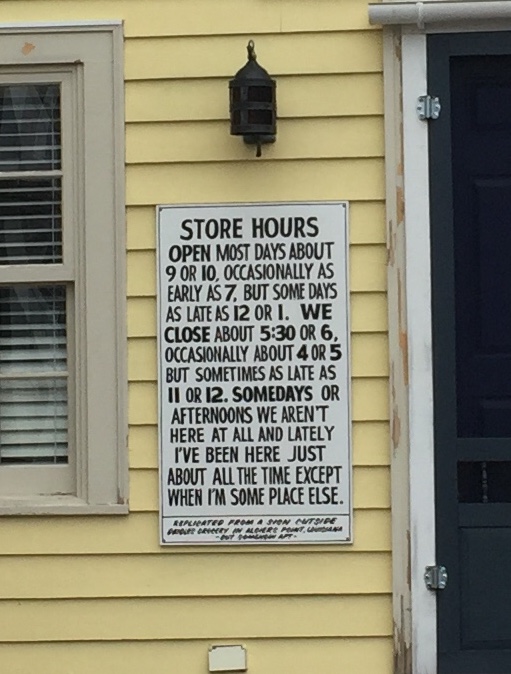 Sign reads: Store hours. Open most days at 9 or 10, occasionally as early as 7 but sometimes as late as 12 or 1. We close most days at 5:30 or 6 but occasionally as early as 4 and sometimes as late as 11 or 12. Somedays or afternoons we're not here at all but lately we've been here just about all the time except when we're somewhere else. 