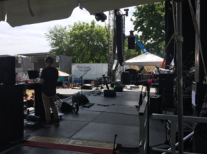 backstage view of mics, gear and a guy doing a soundcheck