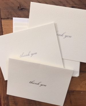 scattered cream-coloured cards with thank-you written in silver script