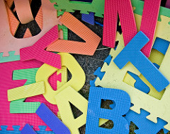 large craft letters in bright colours, strewn about in a random pile