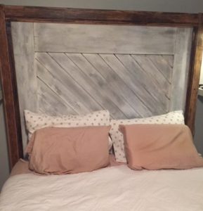 headboard utilizes the bottom of the old door which is now a distressed white. It's framed in oak trim that's been stained medium-dark.